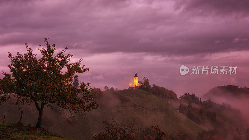 在日出的Jamnik教堂St Primus和felian，阿尔卑斯山，斯洛文尼亚的风景。令人惊叹的风景与人行道和戏剧性的天空，户外旅行背景